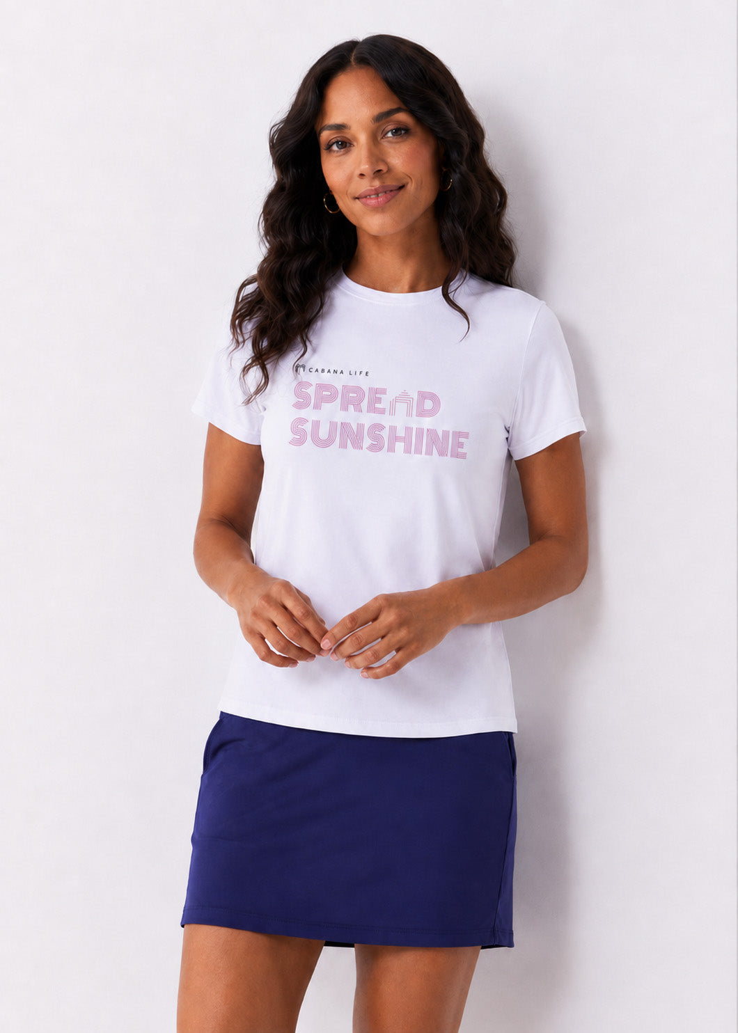 Woman wearing a white t-shirt with pink text and a navy blue skirt on a white background