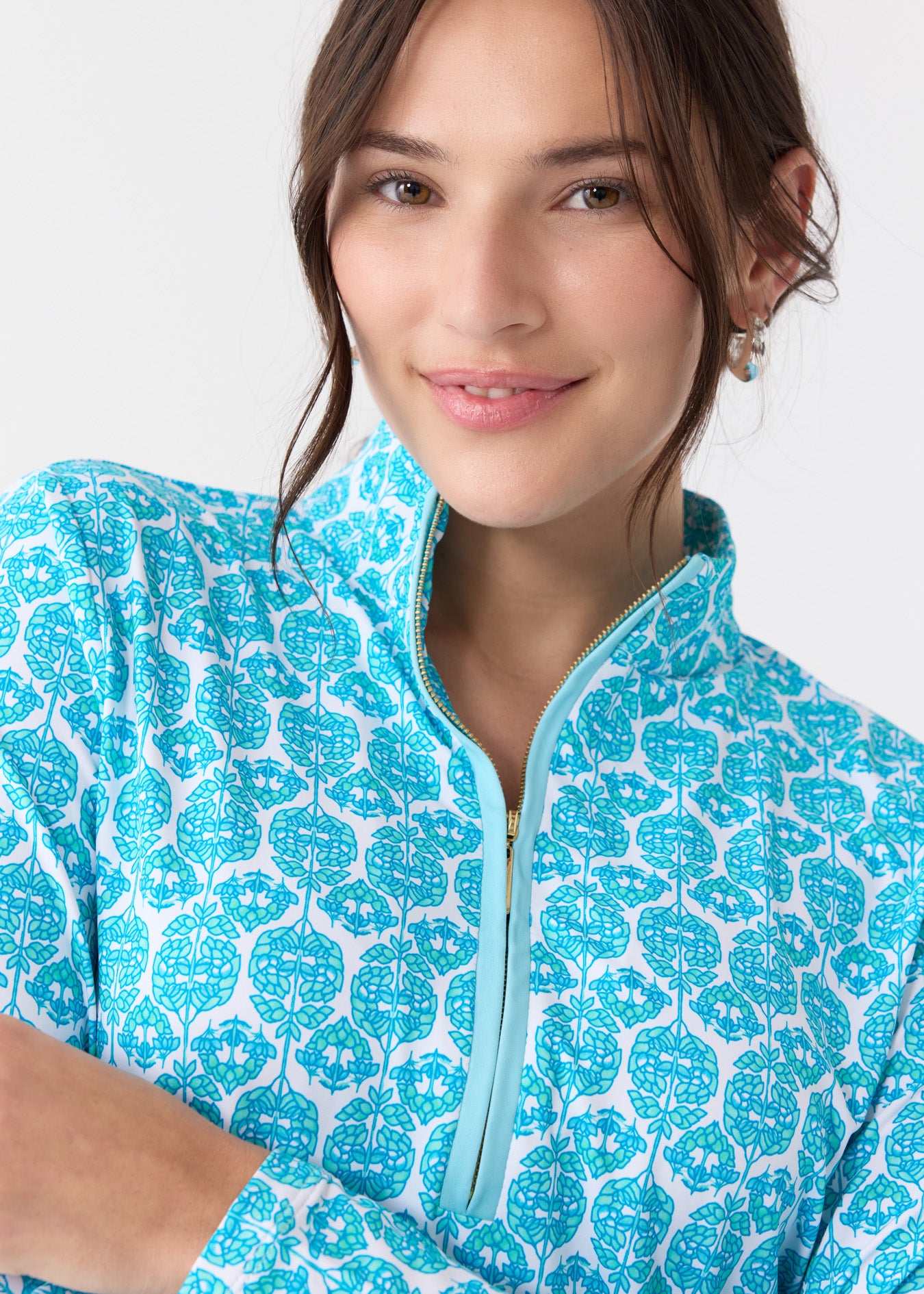 A brunette woman wearing the Cabana Life sun protective Rosemary Beach Performance 1/4 Zip Sport Top.