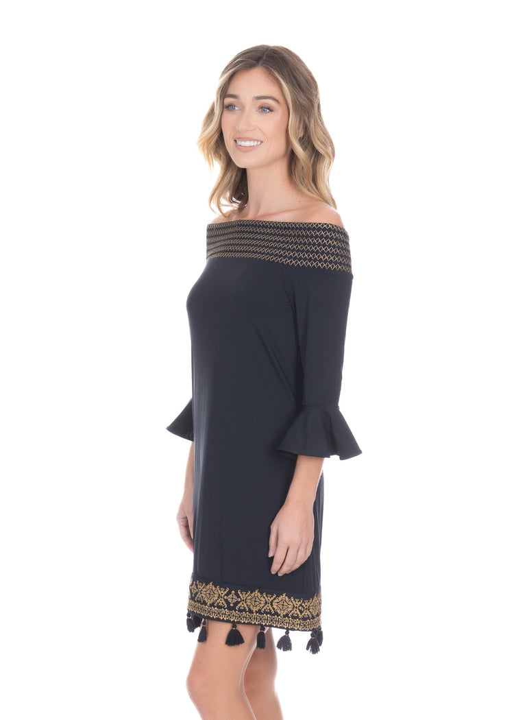 Side facing blonde woman wearing the Black/Gold Metallic Embroidered Off The Shoulder Dress with hands at sides.