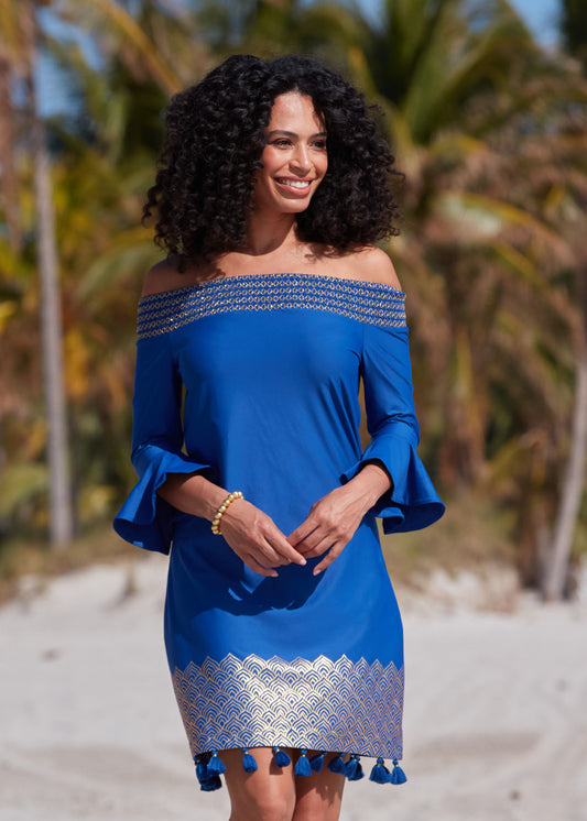 Black woman with arms in front wearing Navy Metallic Off The Shoulder Dress on beach.