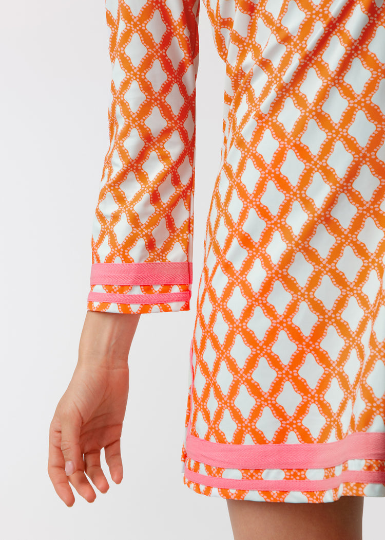 Orange and white patterned dress with pink accents on a white background