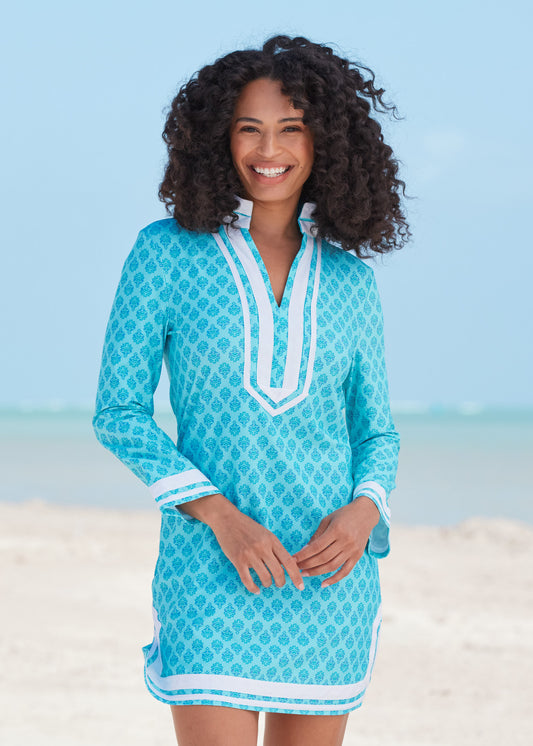 Black woman with curly hair wearing Amalfi Coast Tunic Dress with hands in front on beach.