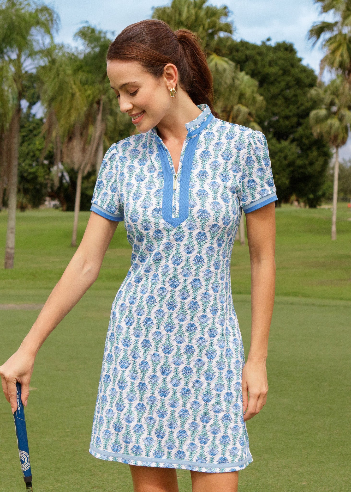 Woman in a blue and white patterned dress on a golf course