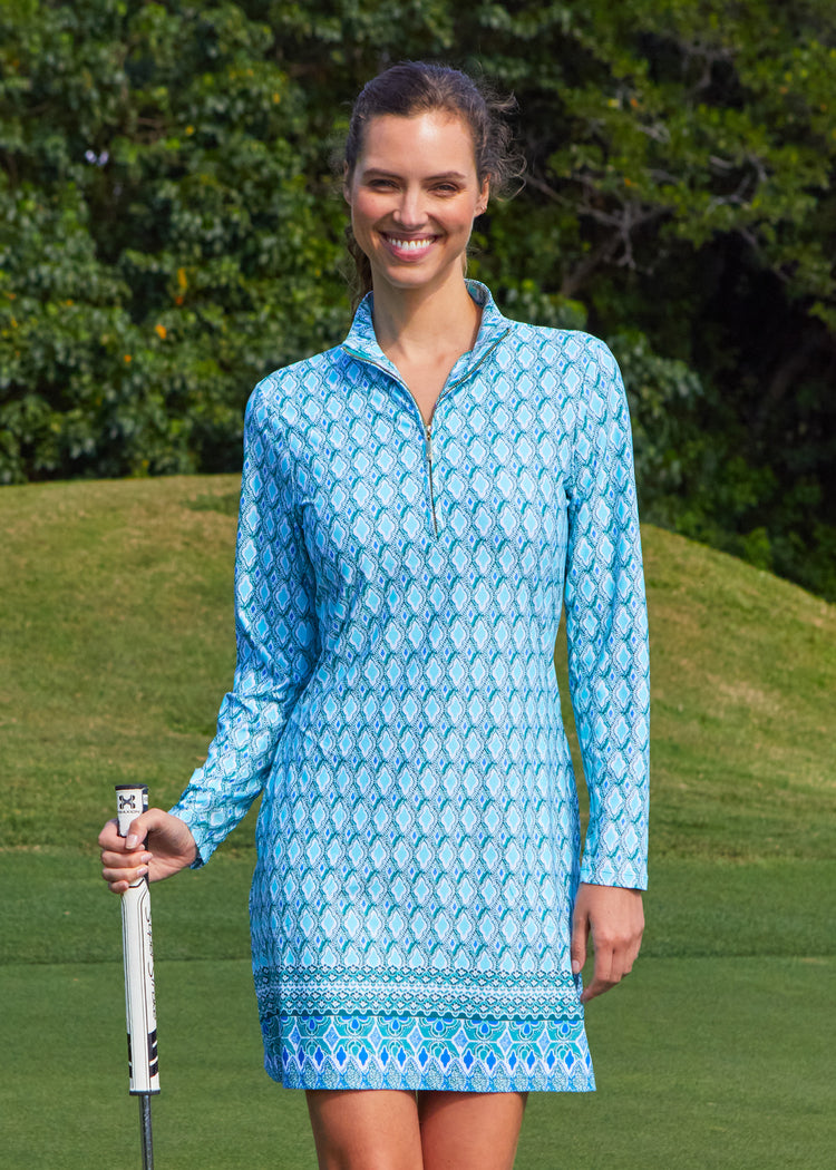 Brunette woman wearing Amalfi Coast 1/4 Zip Sport Dress on golf course holding club.