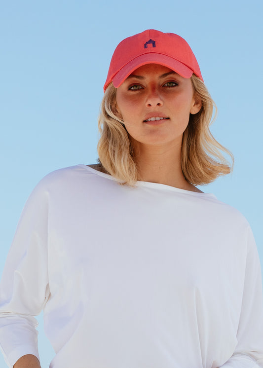 Blonde woman wearing Nantucket Red Cabana Life Baseball Hat with white rashguard.