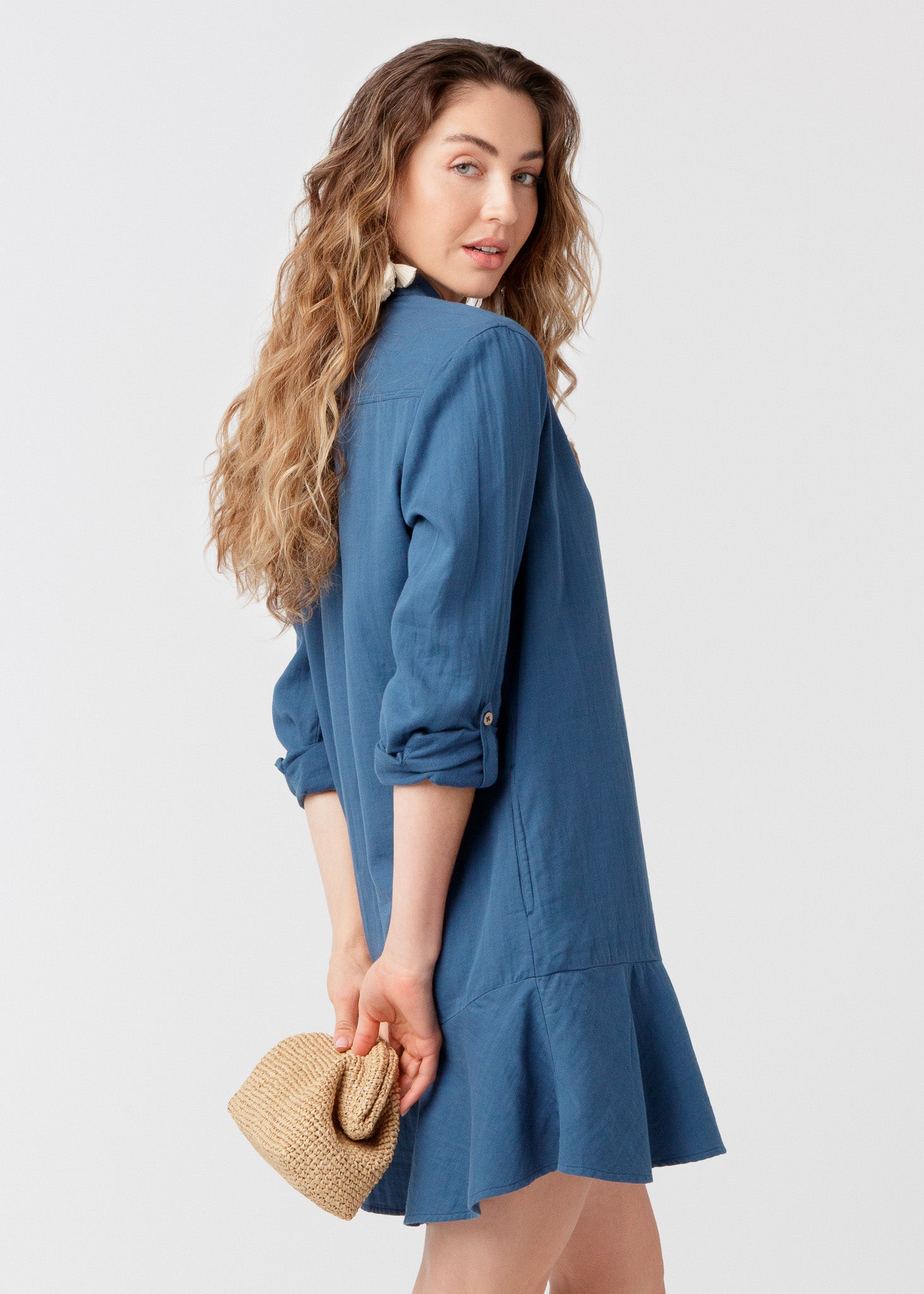 Woman wearing UPF 50+ Harbor Gauze Button Front Shirt Dress with a beige clutch purse