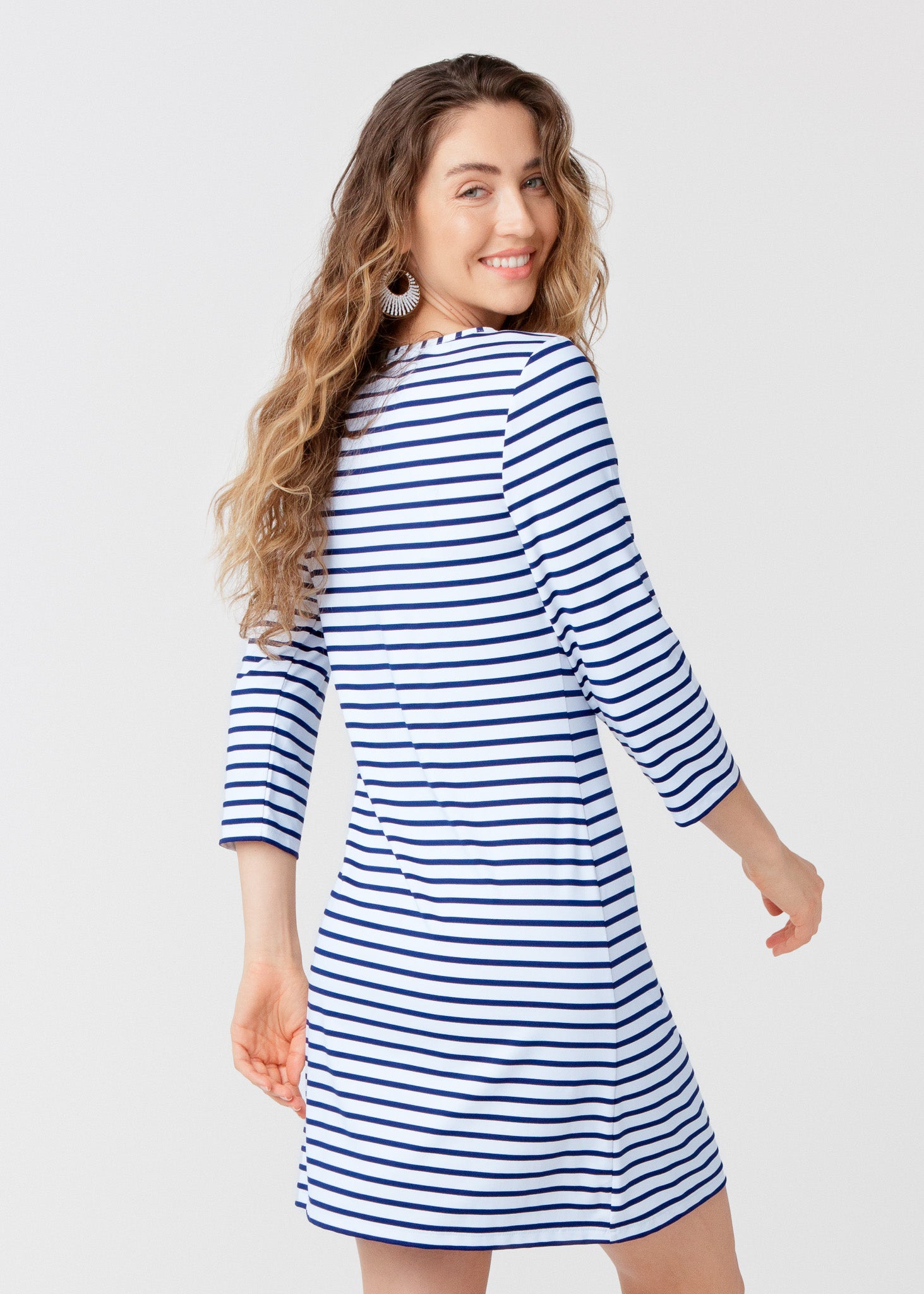 Woman wearing a blue and white striped dress on a plain background