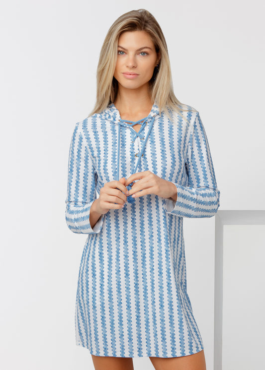Woman wearing a blue and white striped cover up against a plain background
