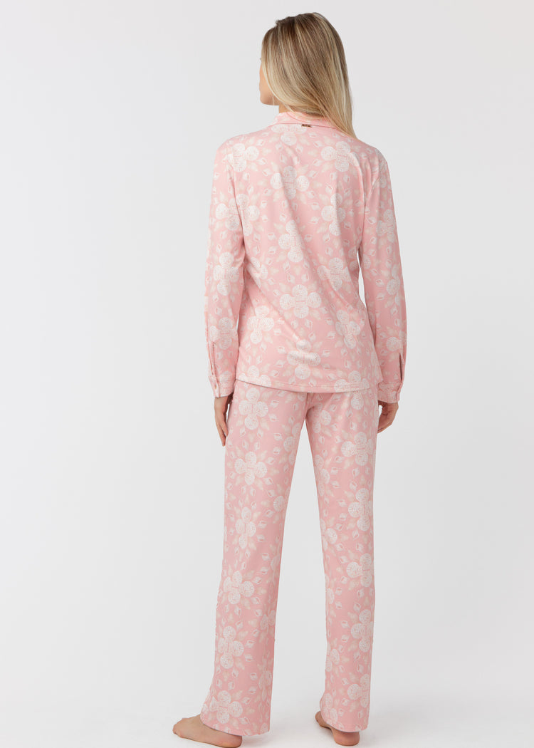 Woman standing with her back facing, wearing our Coast pink and white shell patterned sleep to street pajama set on a white background.
