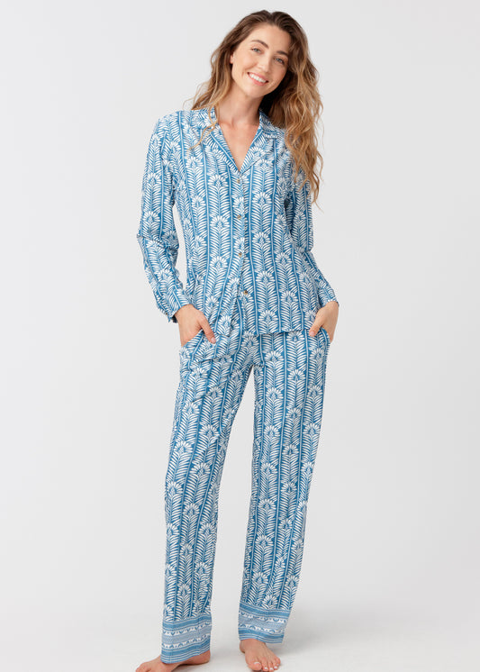 Woman with her hands in her pockets, wearing our Harbor blue patterned sleep to street pajama set on a white background.