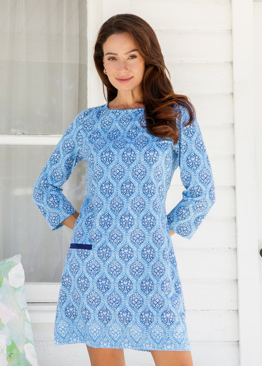 Woman wearing a blue patterned dress against a white background