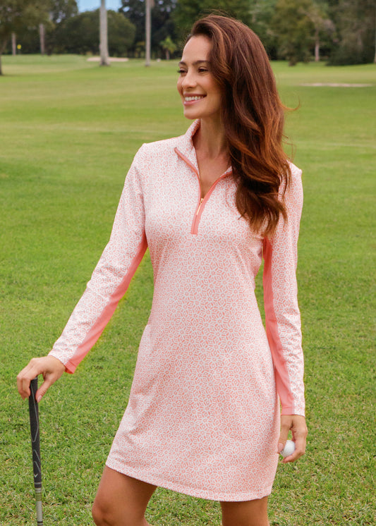 Woman in a pink dress standing on a golf course