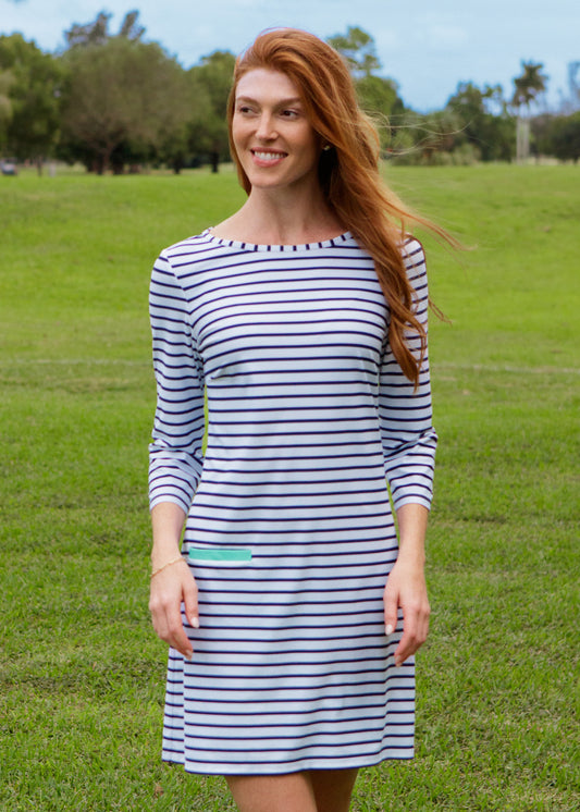 Woman wearing a striped dress standing in a grassy field