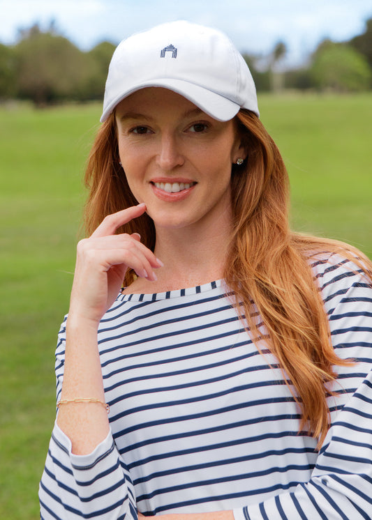 Woman wearing a white cap and striped dress outdoors