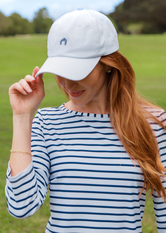 Woman wearing a white cap and striped dress outdoors
