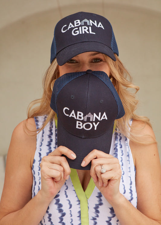 Woman wearing Cabana Girl Hat and holding Cabana Boy Hat in front of face wearing San Sebastian Midi Dress.