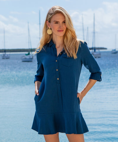 Woman wearing a blue dress by the water.