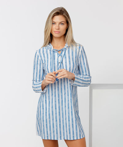 Woman wearing a blue and white striped cover up on a white background.