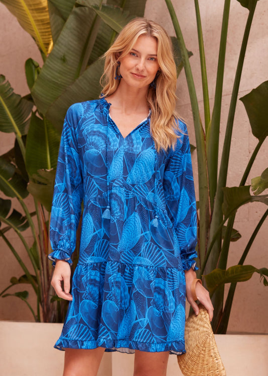 Woman wearing the blue patterned sun protective Cabana Life San Sebastian Tiered Ruffle Dress.