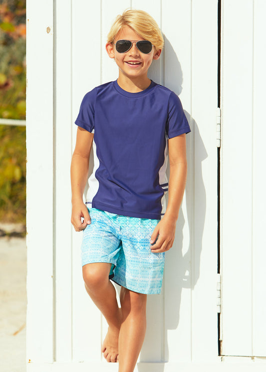 Boy wearing Cabana Life Boys Navy Short Sleeve Rashguard with Boys Coastal Cottage Swim Trunks