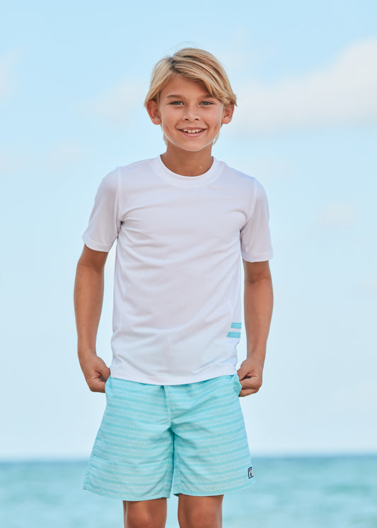 Boy wearing Naples Swim Trunks and White Short Sleeve Rashguard.