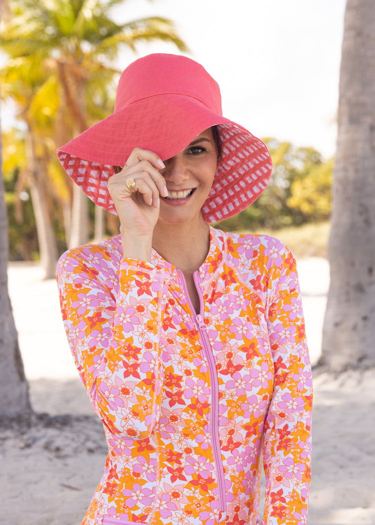 Woman wearing Nantucket/Coral Reversible Bucket Hat and Surfside Unisuit