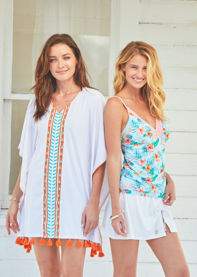Woman wearing Cabana Life Cayman Tankini Top and White Side Tie Swim Skirt and woman wearing Cayman Embroidered Cover Up