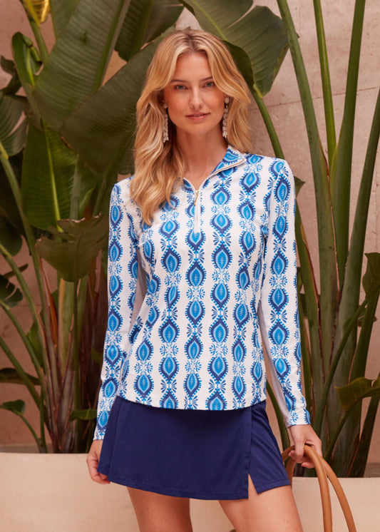 A woman at a beach resort wearing the blue, printed and UPF50+ San Sebastian 1/4 Zip Sport Top from Cabana Life.