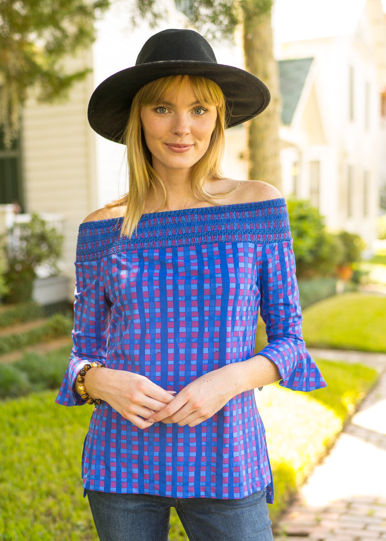 Woman wearing Bar Harbor Off The Shoulder Top with jeans & black hat