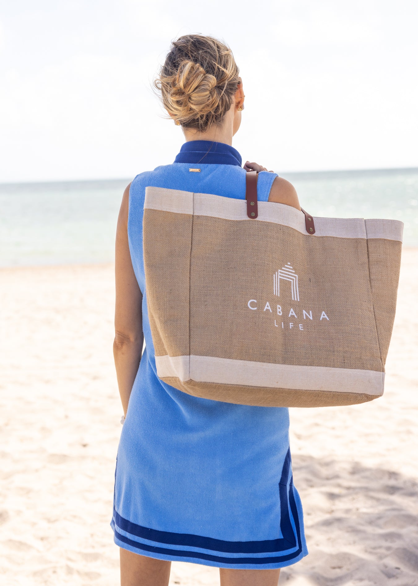 Woman holding Woman holding White Cabana Life Beach Bag on beach